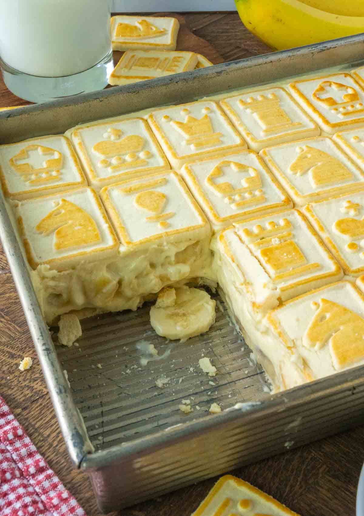 A pan of chessman banana pudding with a corner of the pudding missing.
