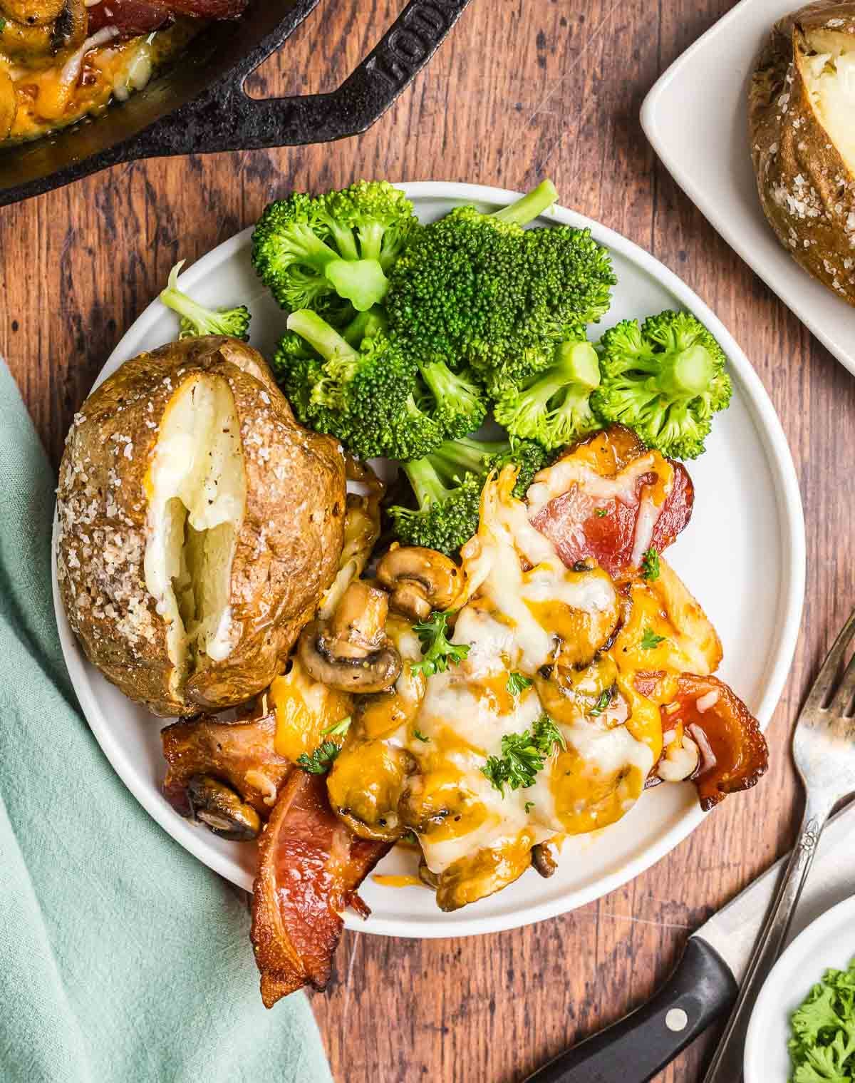A plate of copycat alice springs chicken served with broccoli and a baked potato.
