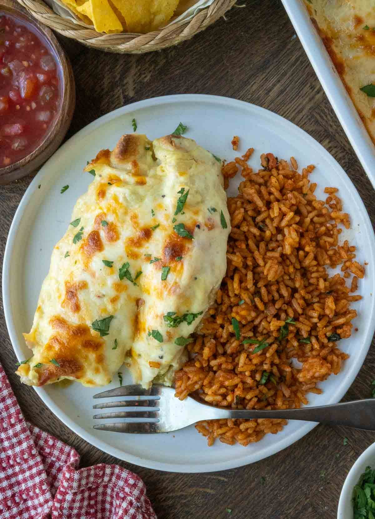 A plate of rotisserie chicken enchilada recipe served with rice.