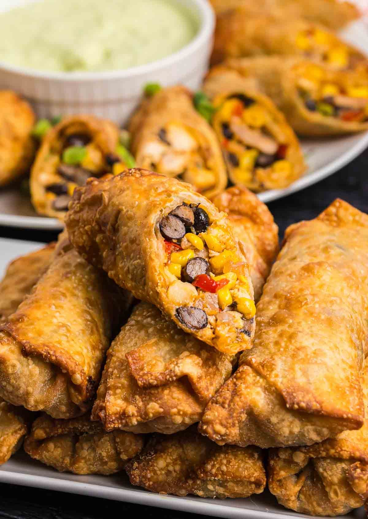 Tex mex egg rolls stacked on a plate.