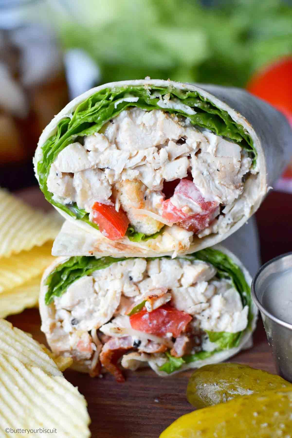 Chicken caesar salad wrap with a side of potato chips