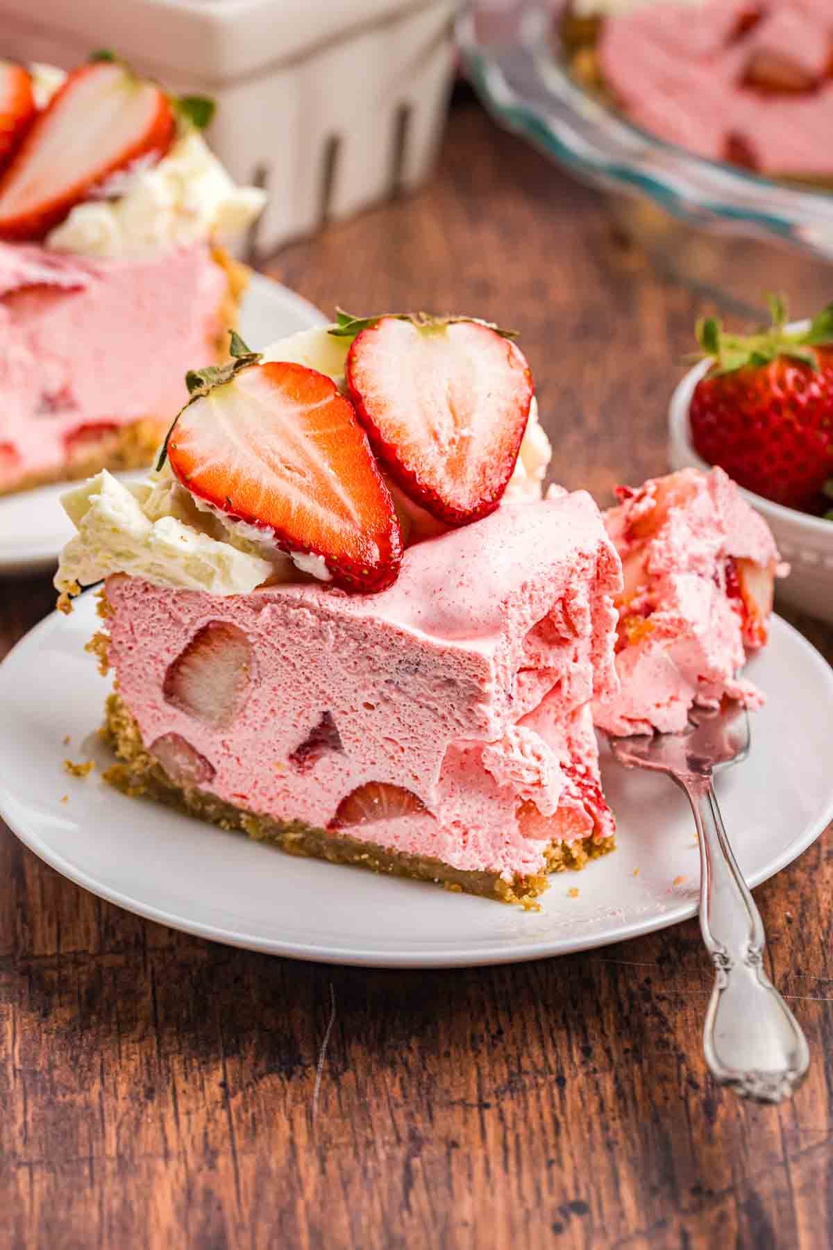 A slice of strawberry cool whip pie on a plate with a fork.