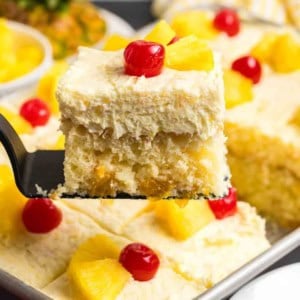 Lifting a piece of sunshine cake from a baking pan.