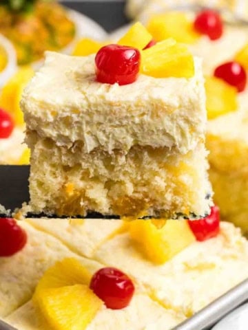 Lifting a piece of sunshine cake from a baking pan.