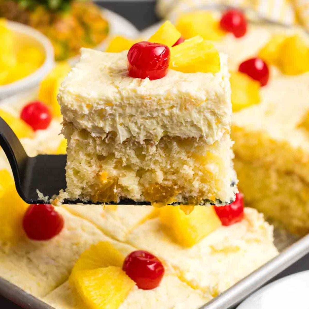 Lifting a piece of sunshine cake from a baking pan.