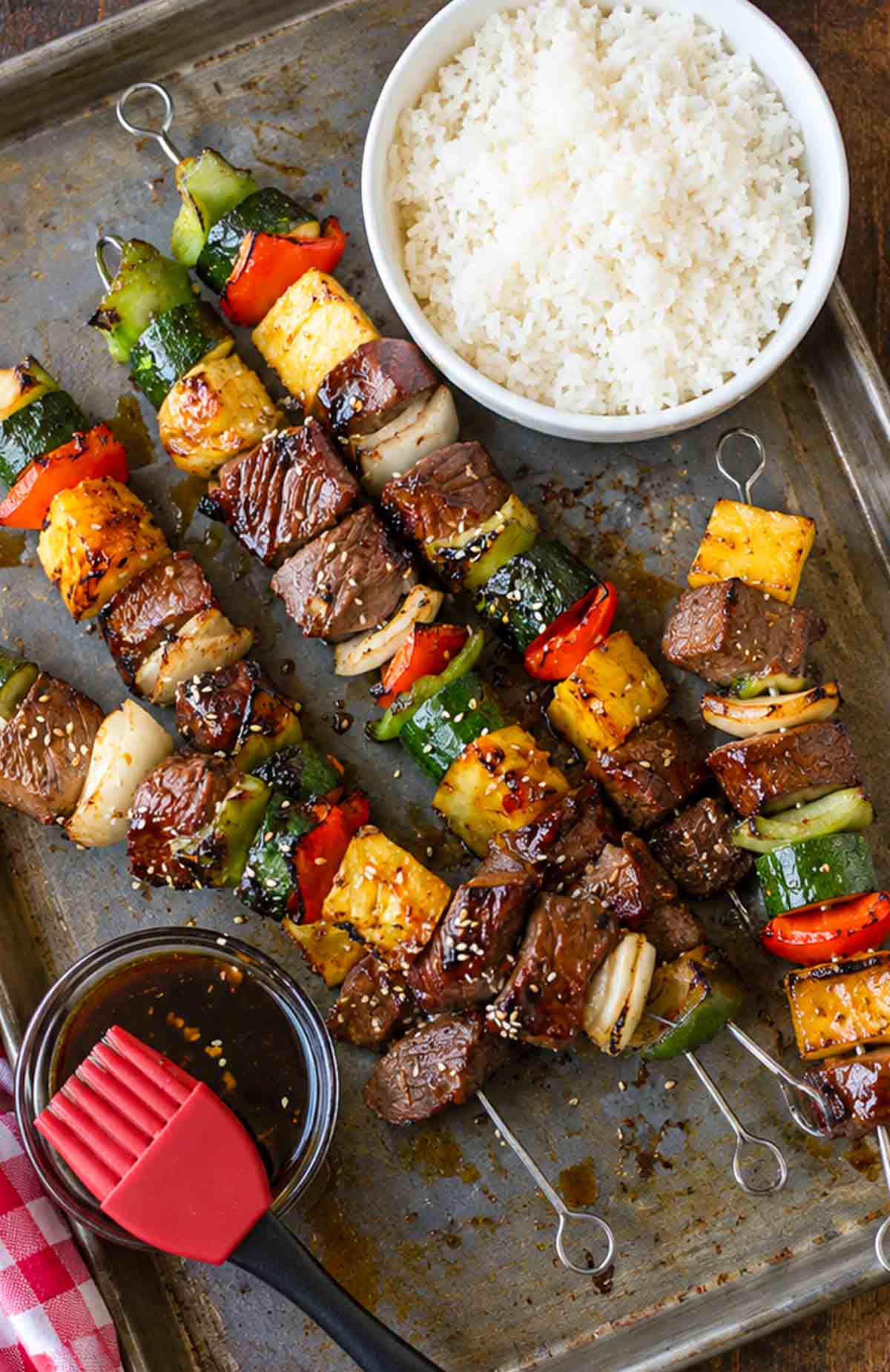 Spicy teriyaki steak kebabs on a baking sheet.