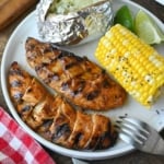 Chipotle honey chicken served with corn and a baked potato.