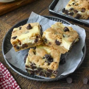 Close up of 3 cookie cheesecake bars on a plate.