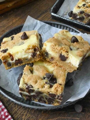 Close up of 3 cookie cheesecake bars on a plate.