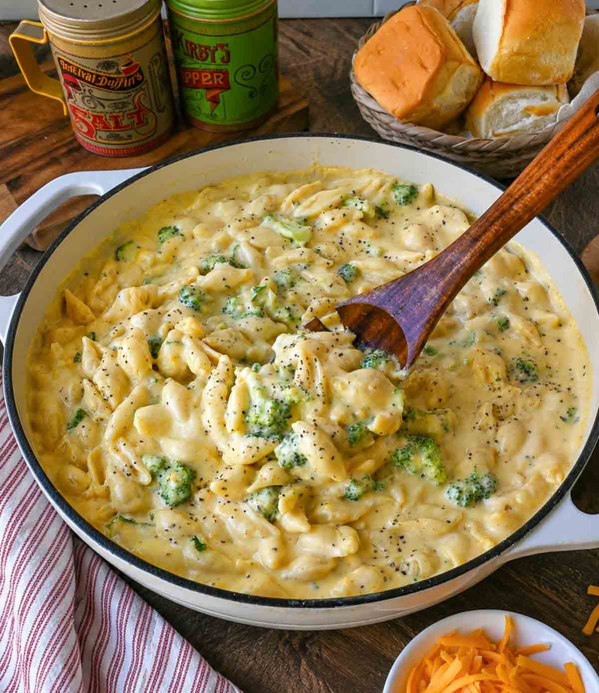 Mixing broccoli mac and cheese with a wooden spoon.
