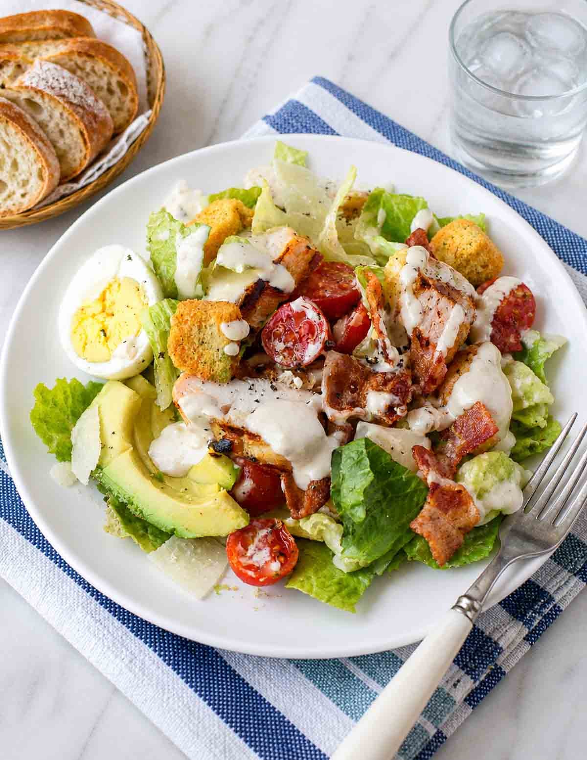 A plate of grilled chicken cobb caesar salad.