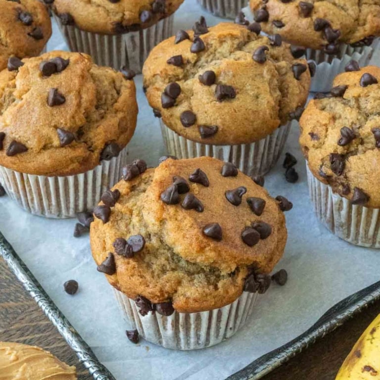 Easy peanut butter banana muffins on a parchment paper lined baking sheet.