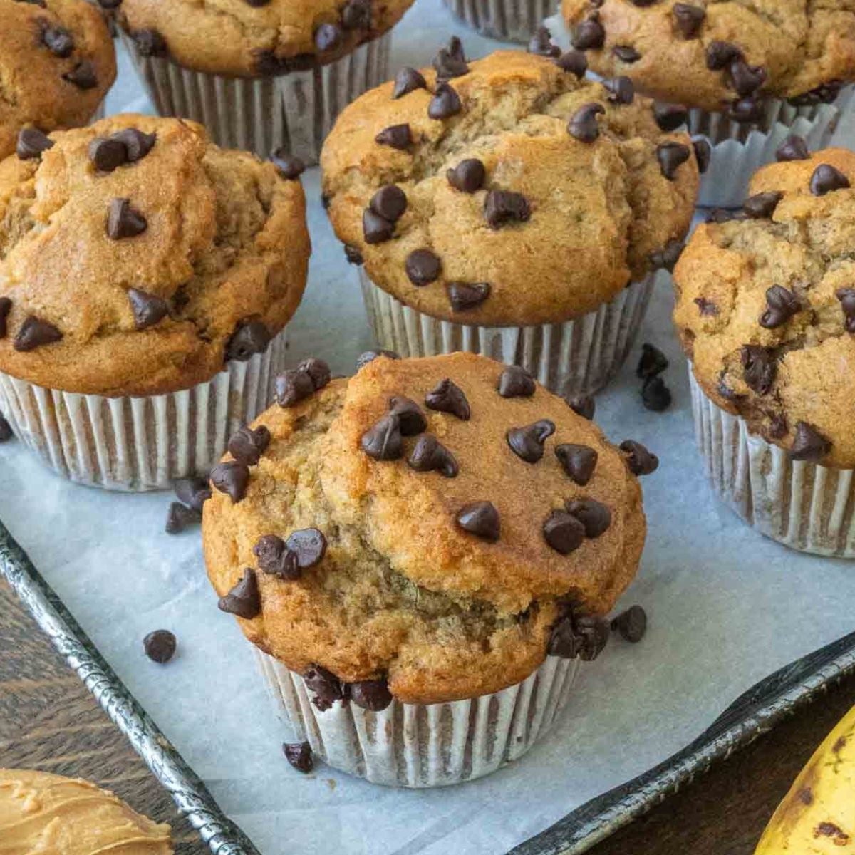 Easy peanut butter banana muffins on a parchment paper lined baking sheet.