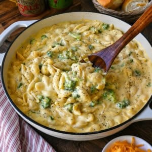 Mixing broccoli mac and cheese with a wooden spoon.