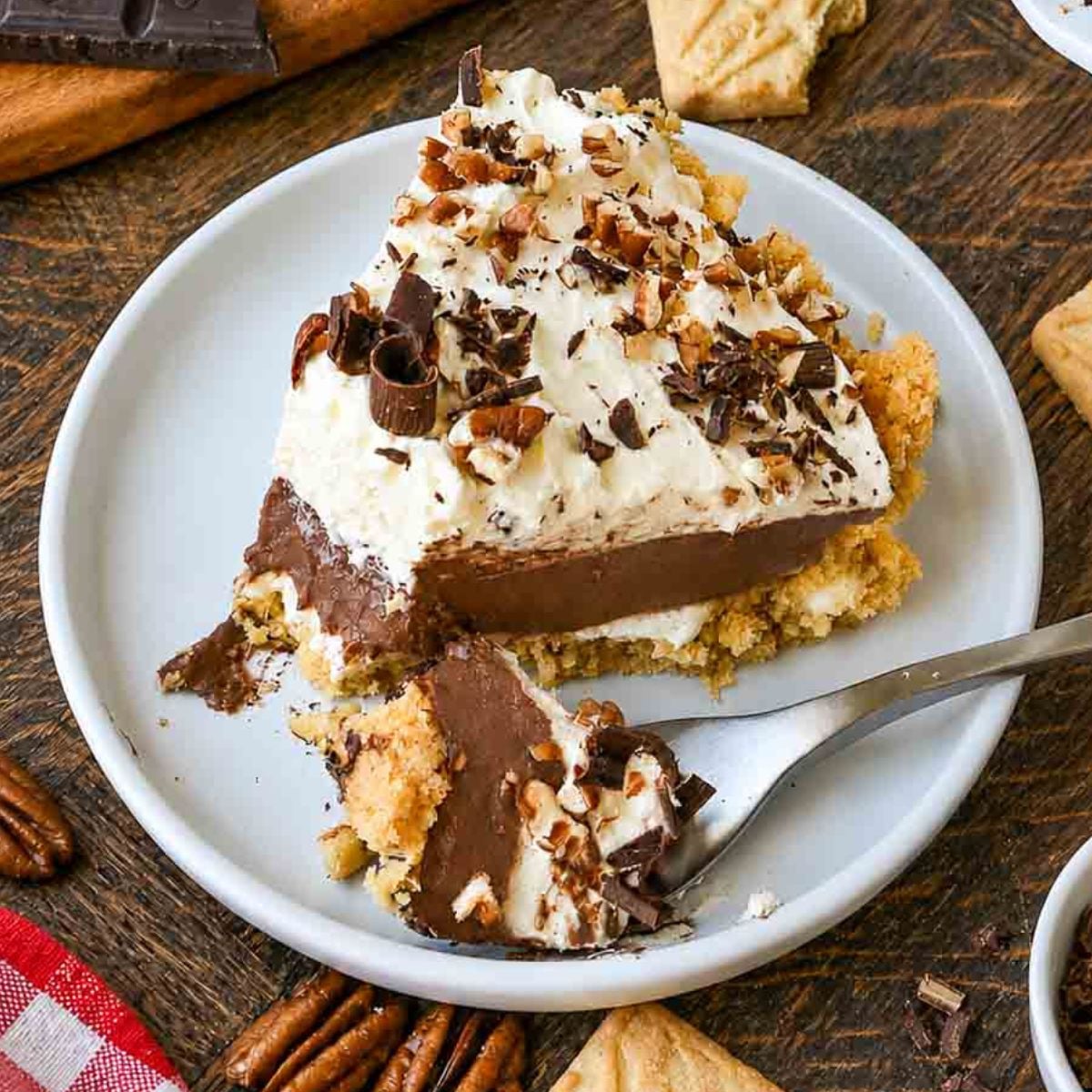 A plate with a slice of possum pie and a fork that's taken one scoop from the front of the slice.