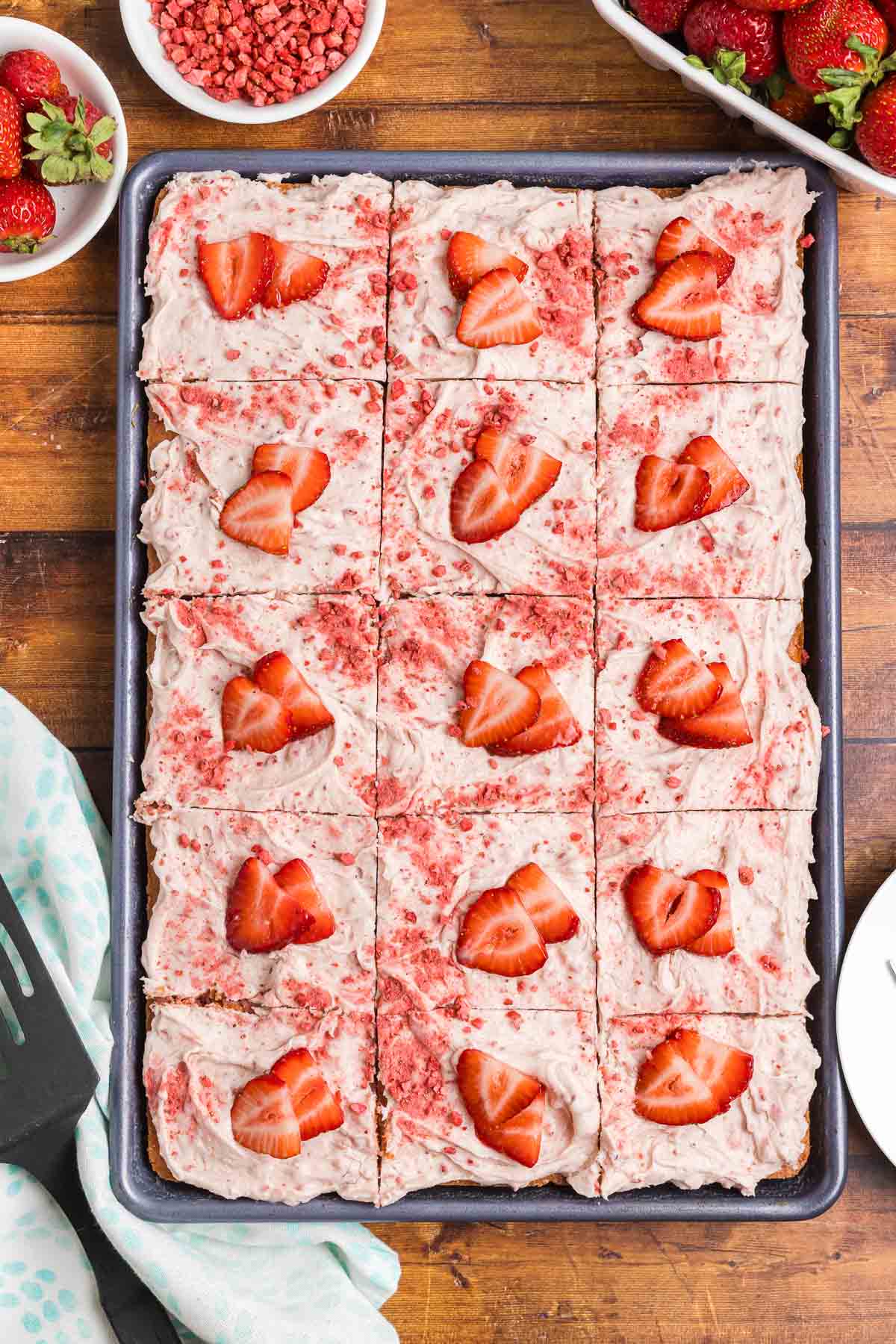 Top down view of a perfectly sliced strawberry sheet cake.