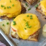 Several open face tuna melts on a baking sheet.