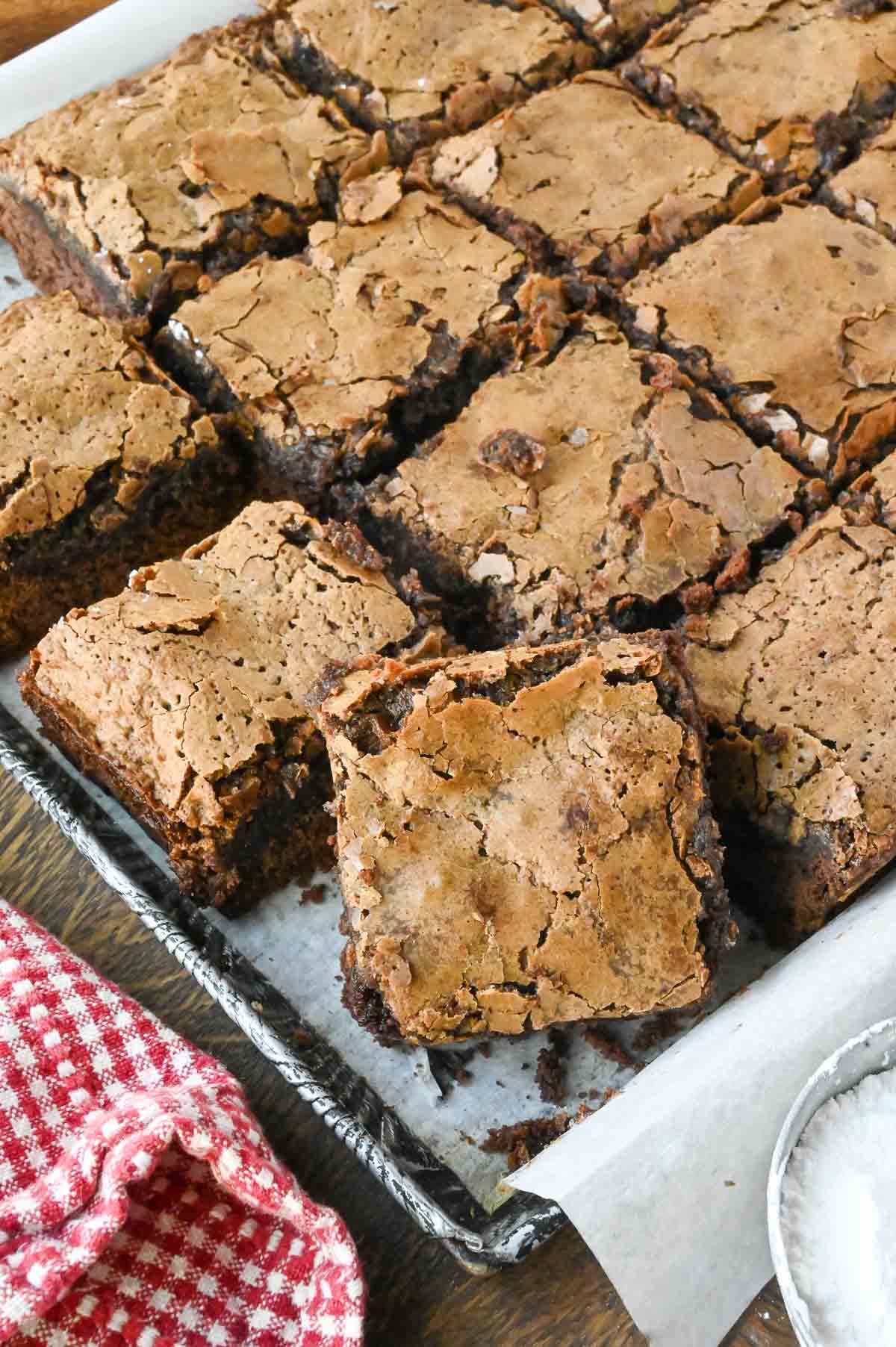 A baking tray with slices of gooey chocolate butter cake.