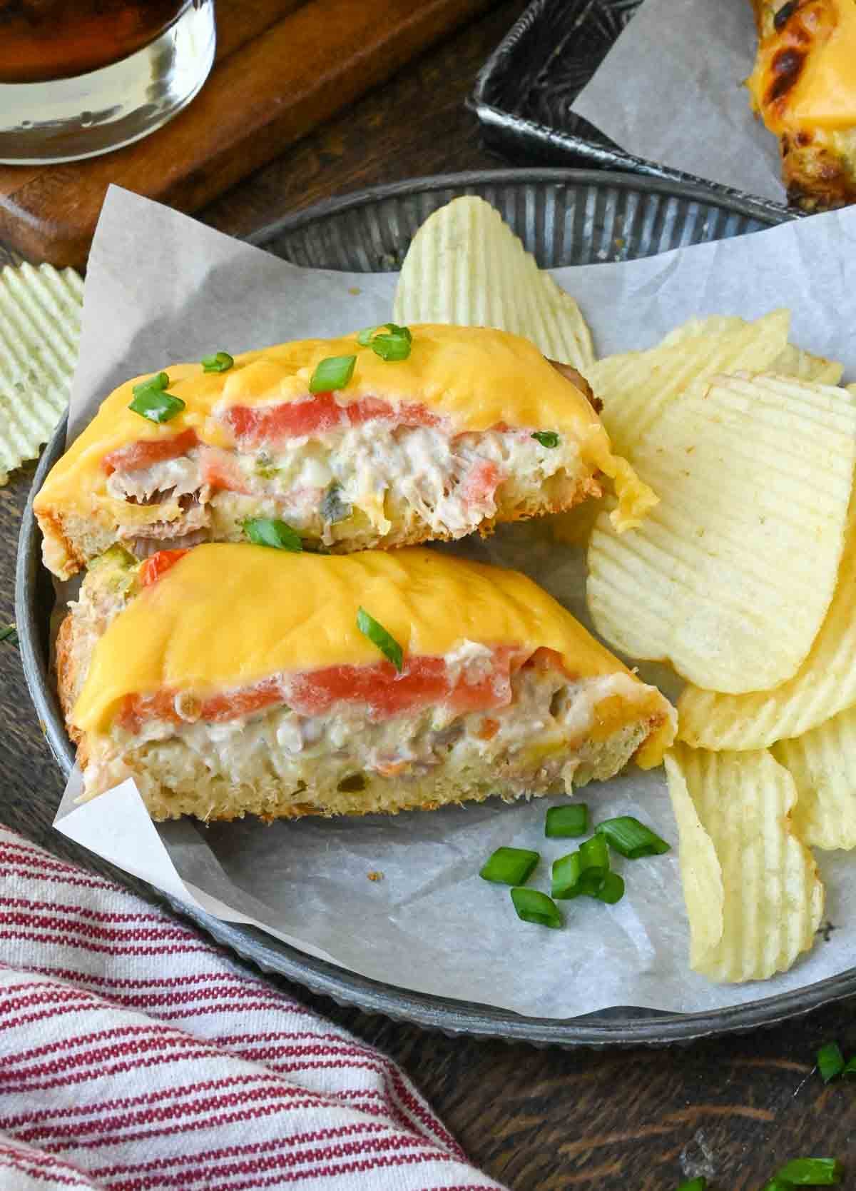 Open face tuna melts in a basket with potato chips.