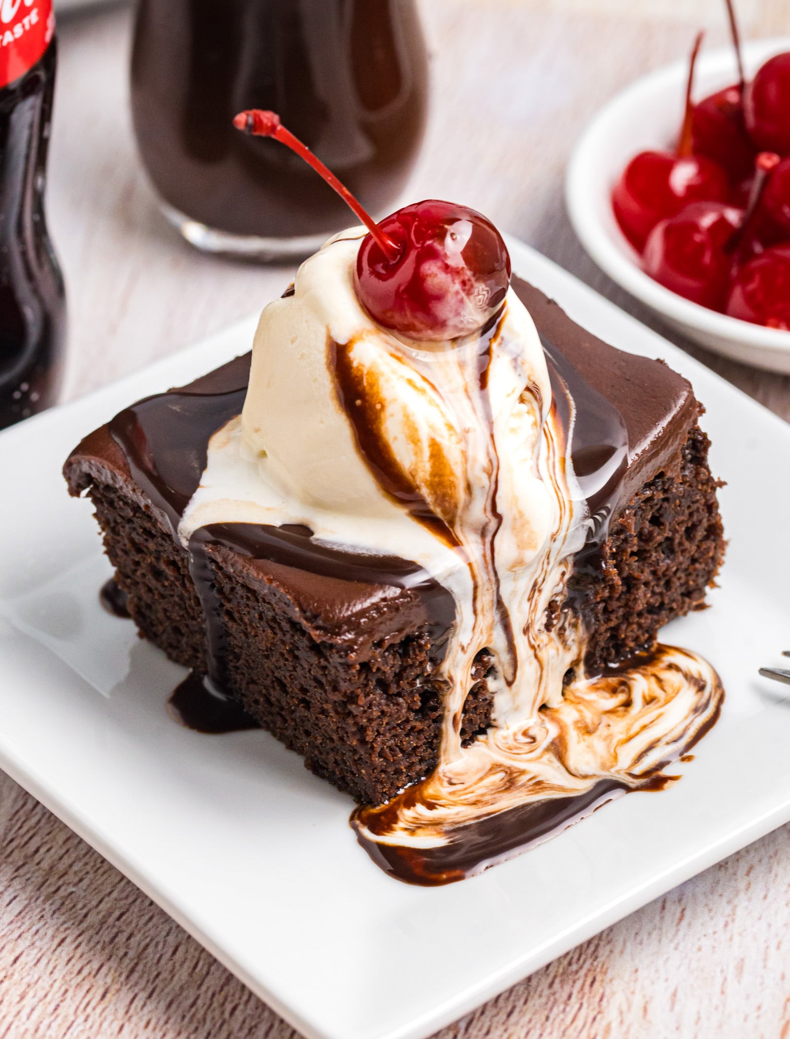 Cracker barrel coca cola cake on a plate with ice cream on top.