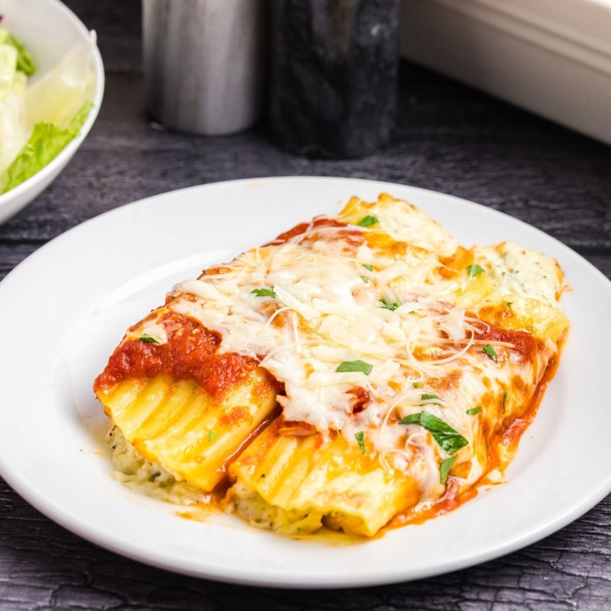 Four cheese manicotti on a plate.