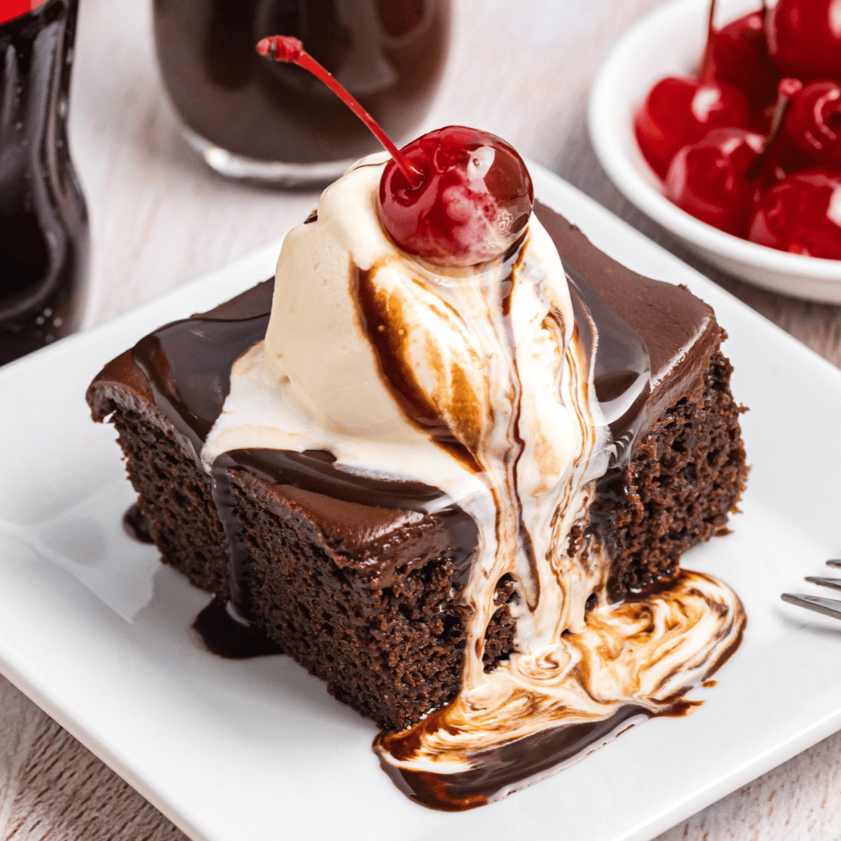 Cracker barrel coca cola cake on a plate with ice cream on top.