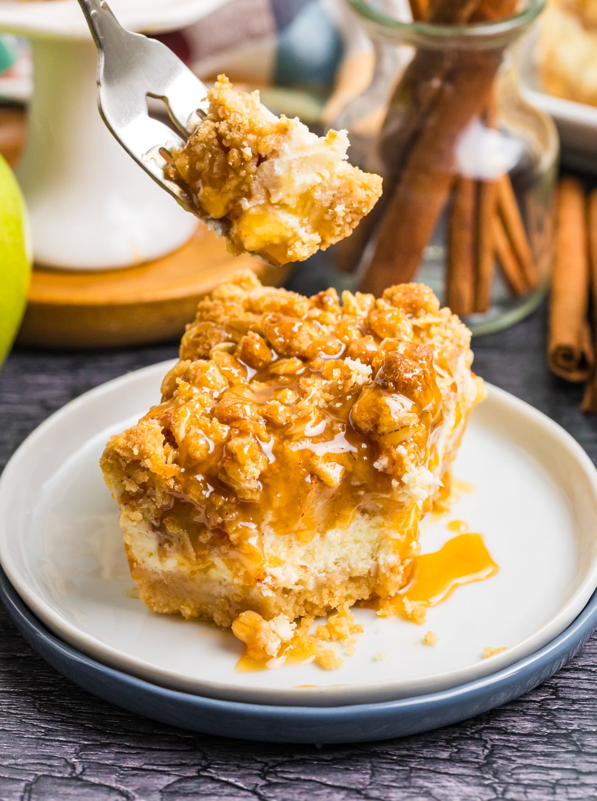 A fork removing a bite of these apple cheesecake bars.