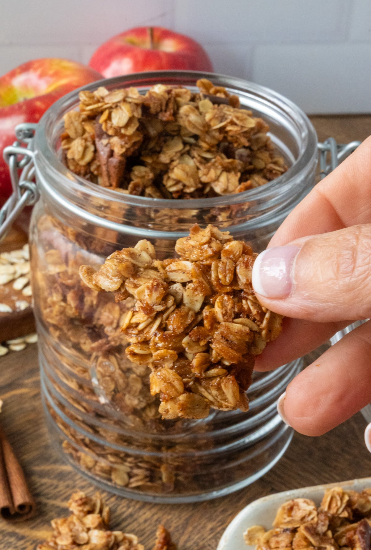 A chunk of apple granola being picked up.