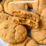 Pumpkin snickerdoodles cookies piled on a baking sheet.
