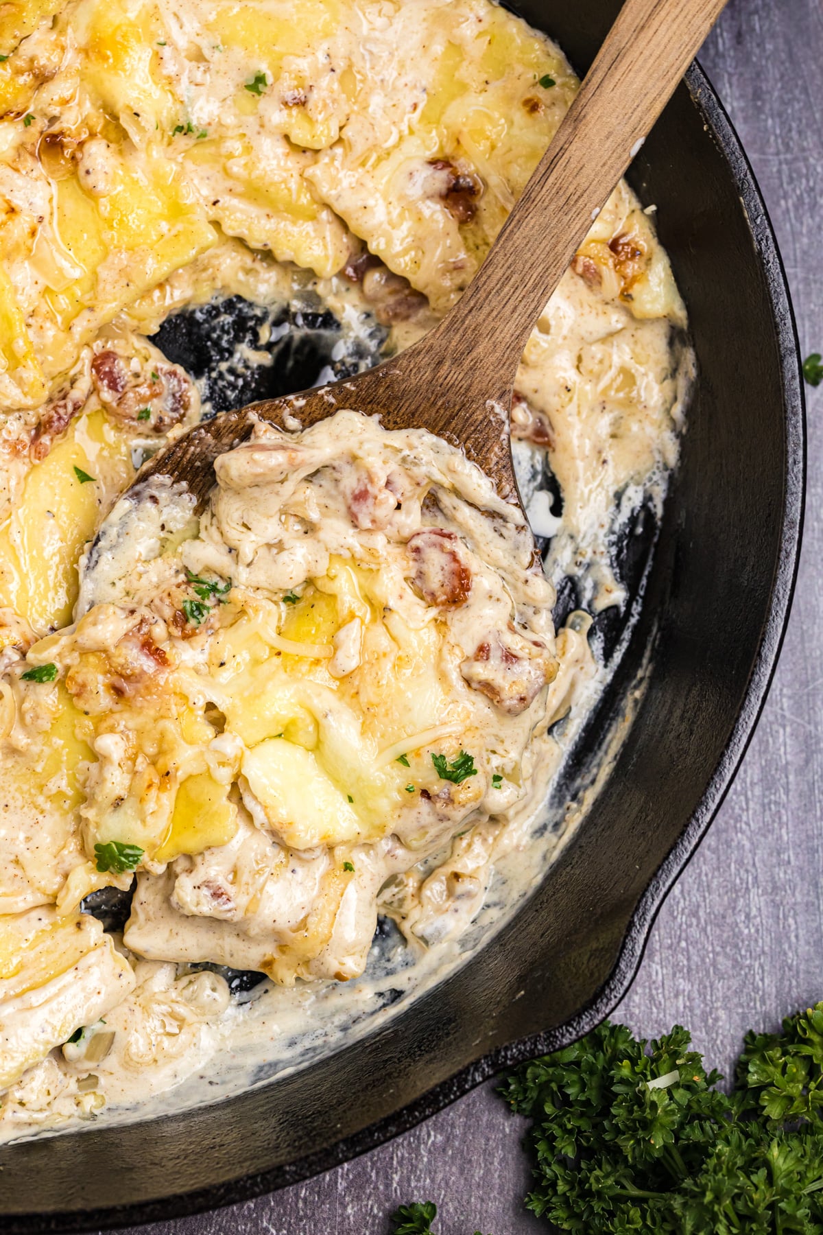 Olive Garden Ravioli Carbonara in a cast iron skillet with a wooden spoon.