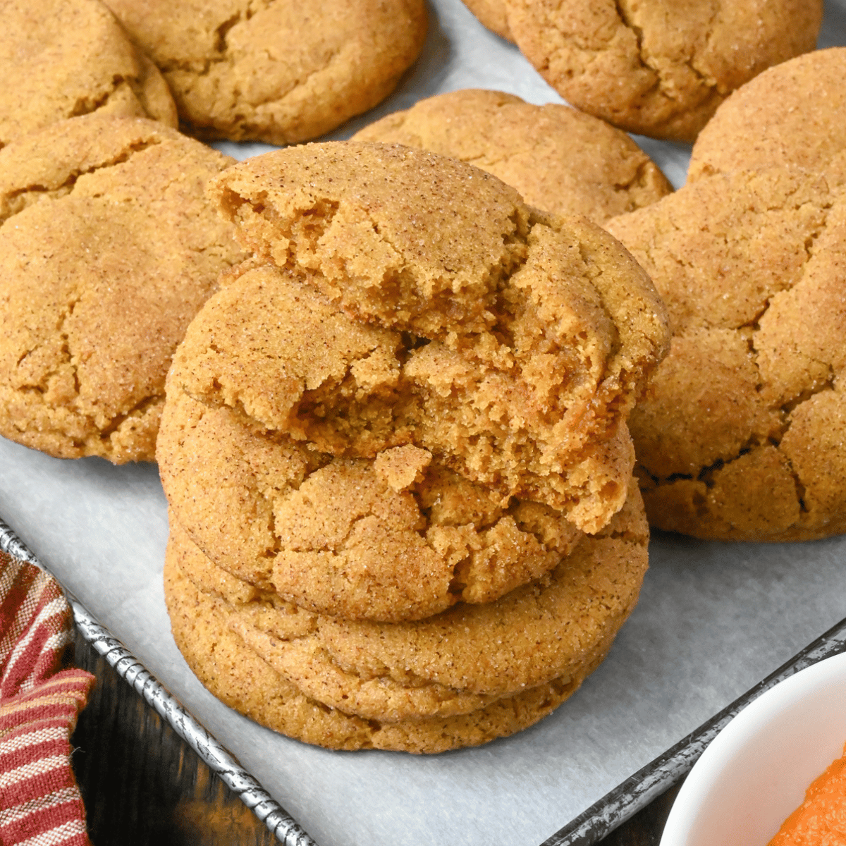 Pumpkin snickerdoodles cookies on a baking sheet.