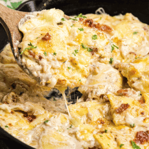 Olive Garden Ravioli Carbonara in a cast iron skillet with a wooden spoon.